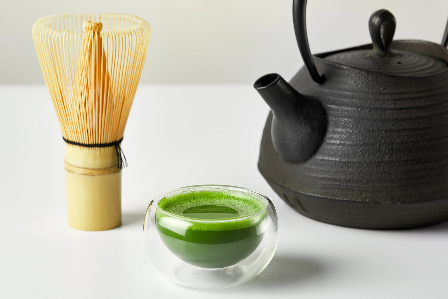 Black tetsubin with bamboo whisk and cup of matcha