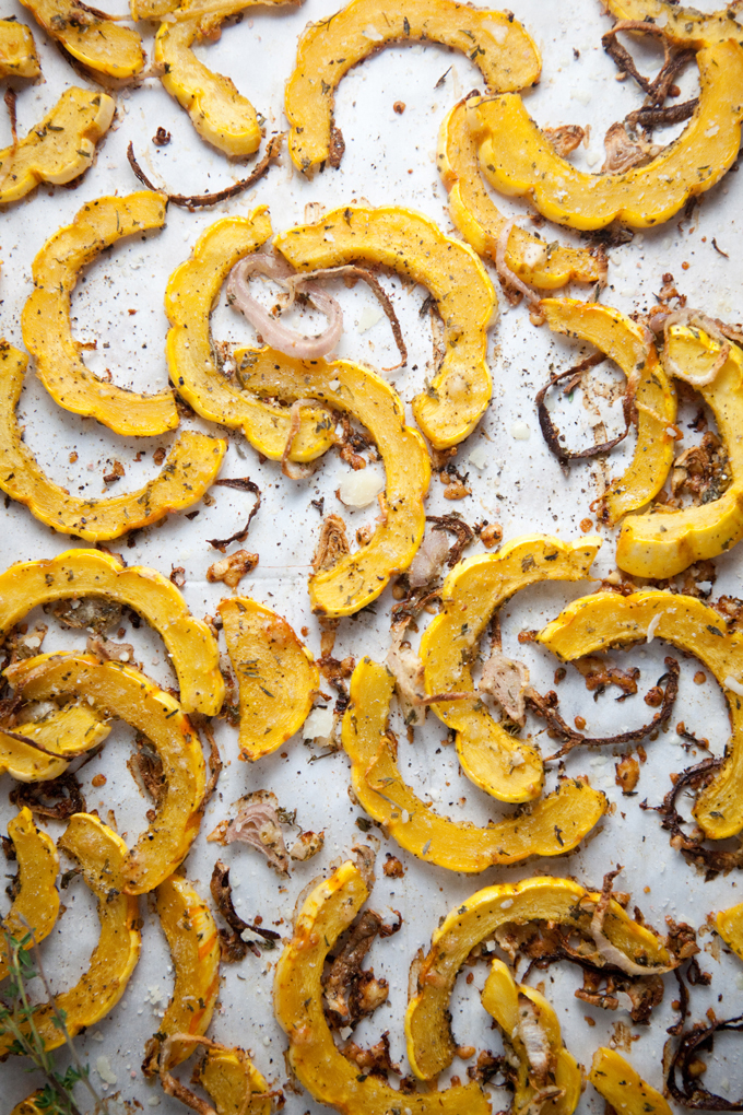 Roasted delicata and shallots on baking tray.