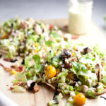 Fresh and Healthy Chopped BLT Salad atop a soft warm greek pita- easy to customize for your macros