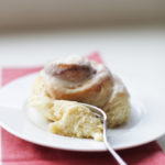 Fork digging into one of my favorite giant cinnamon rolls on a plate.