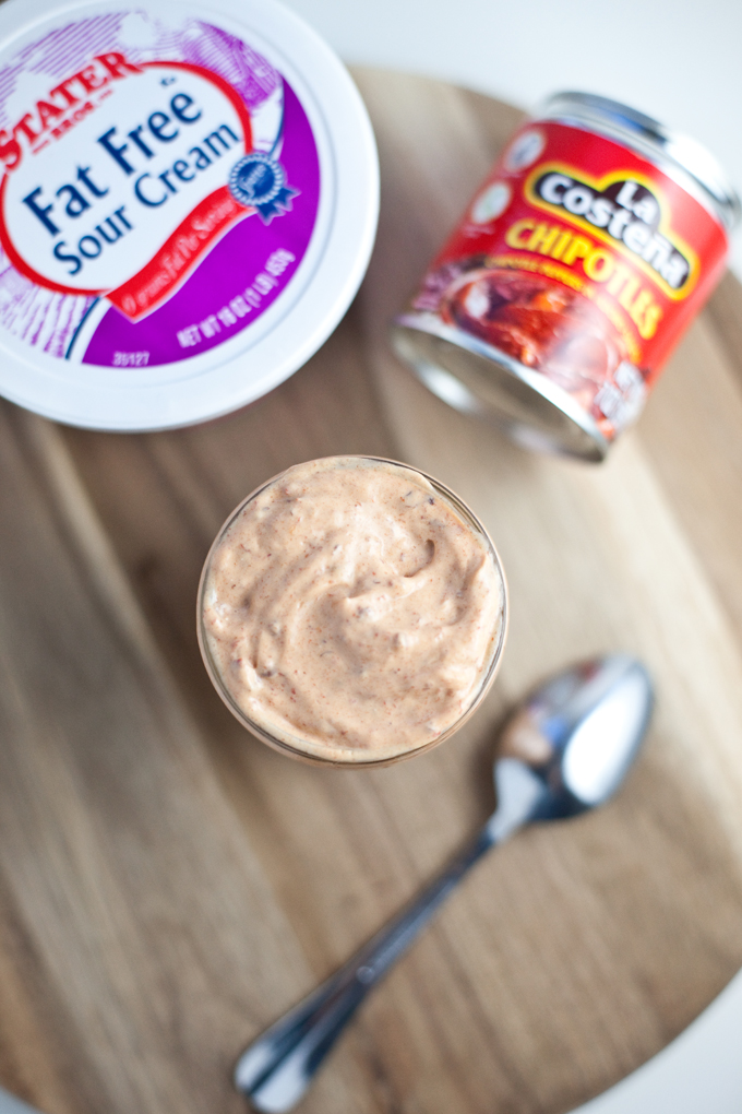 Chipotle sour cream in a jar next to a container of fat free sour cream and chipotle in adobo sauce.