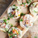 Six egg white veggie mini quiches on wood cutting board.