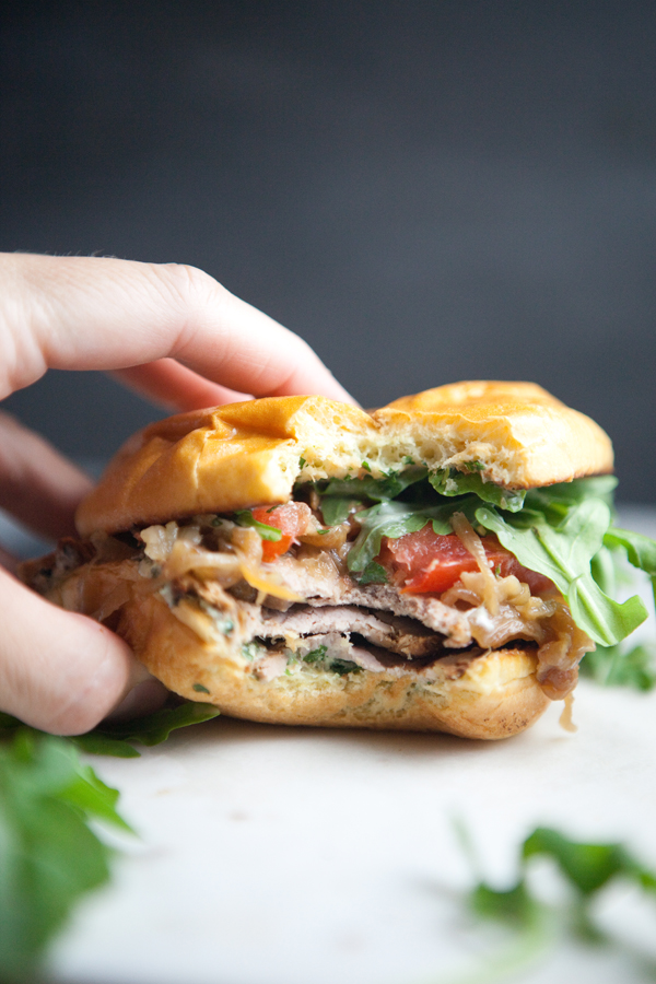 Pork tenderloin sandwich with a bite taken out of it.