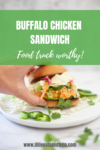 A hand holds an Easy Buffalo Chicken Sandwich with coleslaw and jalapeños, on a white plate with greens scattered, and text reading Buffalo Chicken Sandwich—Food truck worthy!.