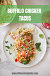 Three Buffalo Chicken Tacos topped with shredded cabbage, pickled onions, cilantro, and a drizzle of sauce are served on a white plate. “BUFFALO CHICKEN TACOS” text is overlaid at the top, with a website link at the bottom.