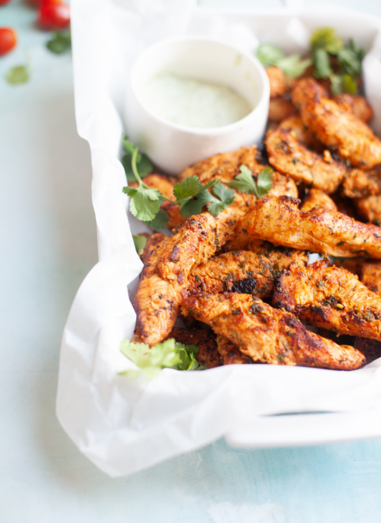 Air fryer chicken tenderloins garnished with fresh cilantro.