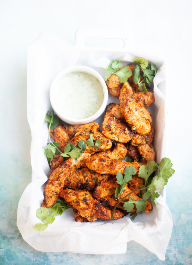 Cilantro lime air fryer chicken tenderloins in a white serving dish.