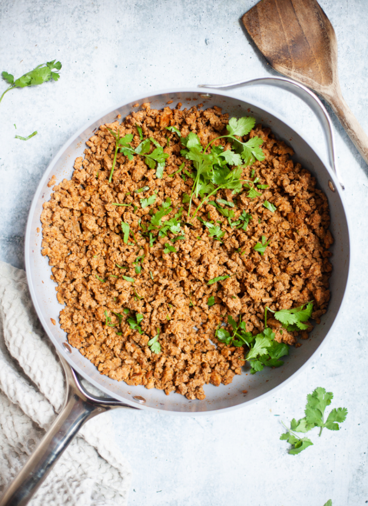 Simply seasoned ground turkey meat in cast iron skillet garnished with cilantro.