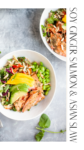 Two white bowls filled with soy ginger salmon, edamame, avocado, mixed greens, Asian slaw, and almond slices sit on a light gray surface. Text on the right reads: Soy Ginger Salmon & Asian Slaw.