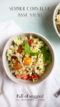 A bowl of vibrant corn feta and basil salad, brimming with cherry tomatoes, red onion, and fresh basil leaves. The text reads SUMMER CORN FETA BASIL SALAD and Full of veggies! lillieeatsandtells.com.