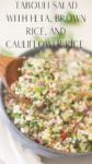Close-up of a bowl of tabouli salad with feta, brown rice, and cauliflower, mixed with chopped vegetables. A wooden spoon is in the bowl, and text describing this vibrant tabouli salad with feta brown rice and cauliflower appears at the top.