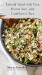 A vibrant bowl of tabouli salad with feta, brown rice, and cauliflower sits on a table, brimming with chopped vegetables and fresh herbs. A wooden spoon rests inside, inviting you to enjoy this wholesome and colorful medley.
