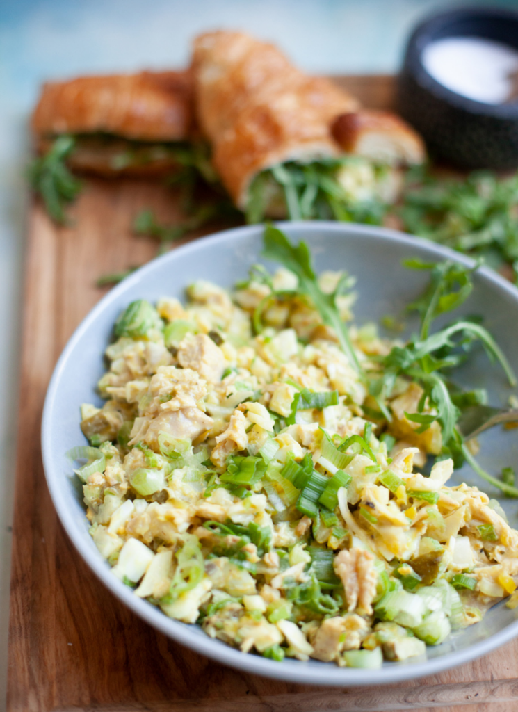 Pickle chicken salad in gray bowl topped with green onions and arugula.