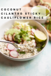 A vibrant bowl of Coconut Cilantro Sticky Cauliflower Rice is topped with crisp sliced radishes, fresh greens, lime wedges, and a drizzle of savory sauce. In the foreground, a fork holds up a perfect bite, showcasing the fluffy texture and colorful medley. Text on image reads Coconut Cilantro Sticky Cauliflower Rice.
