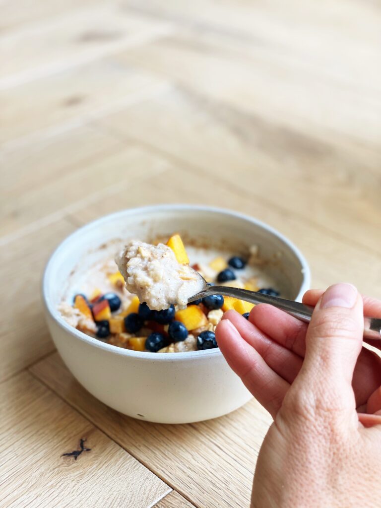 Spoon digging into bowl of breakfast protein cauliflower oats.
