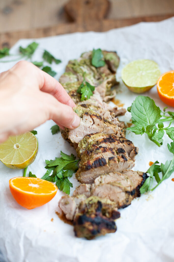 hand eating Cuban Grilled Pork Tenderloin recipe by www.lillieeatsandtells.com