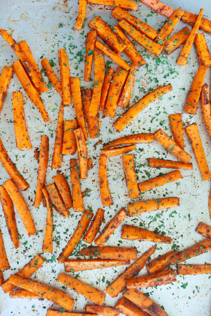 pan of Spicy Carrot Fries with Lemon Cumin Yogurt Sauce | macro friendly sides recipe by www.lillieeatsandtells.com