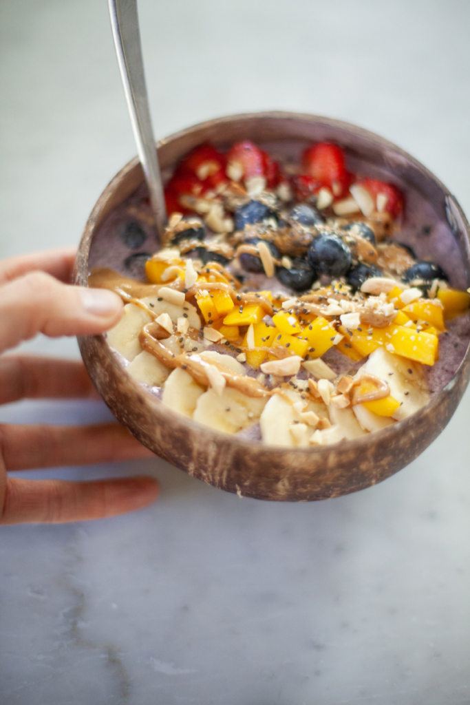 Hand holding high protein berry bowl.
