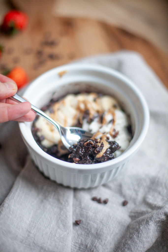 Spoon digging into microwave zucchini brownie oats.