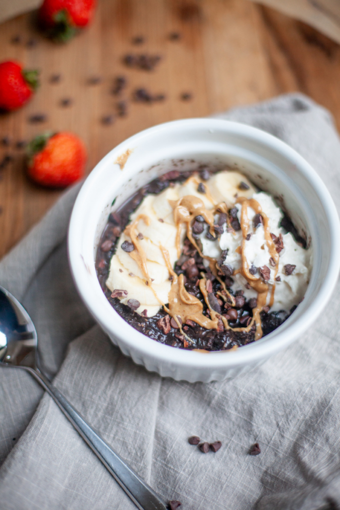 Micorwave zucchini brownie oats in ramekin with toppins.