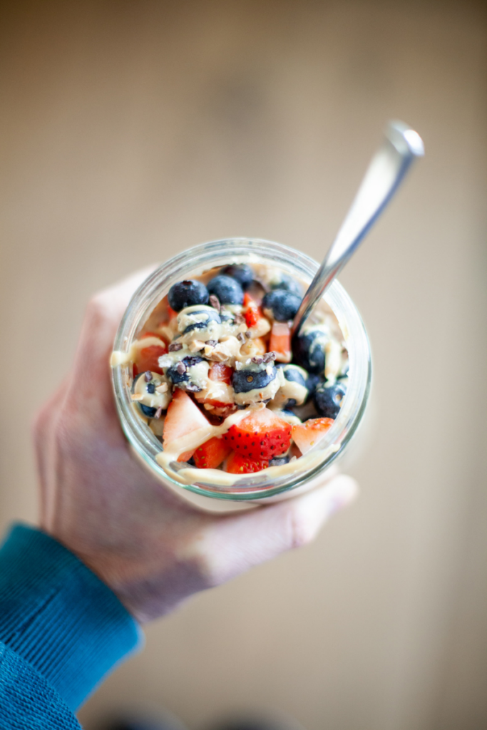 Overnight cauliflower oats with strawberries, blueberries and nut butter on top.