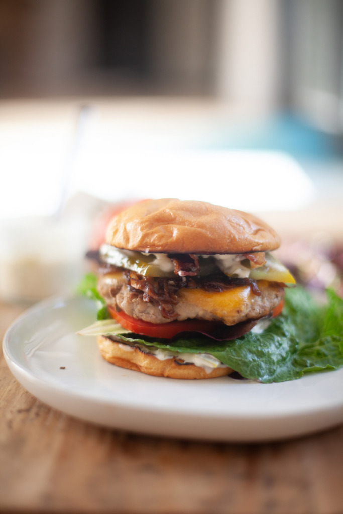 Assembled turkey bacon cheeseburger on a white serving dish.