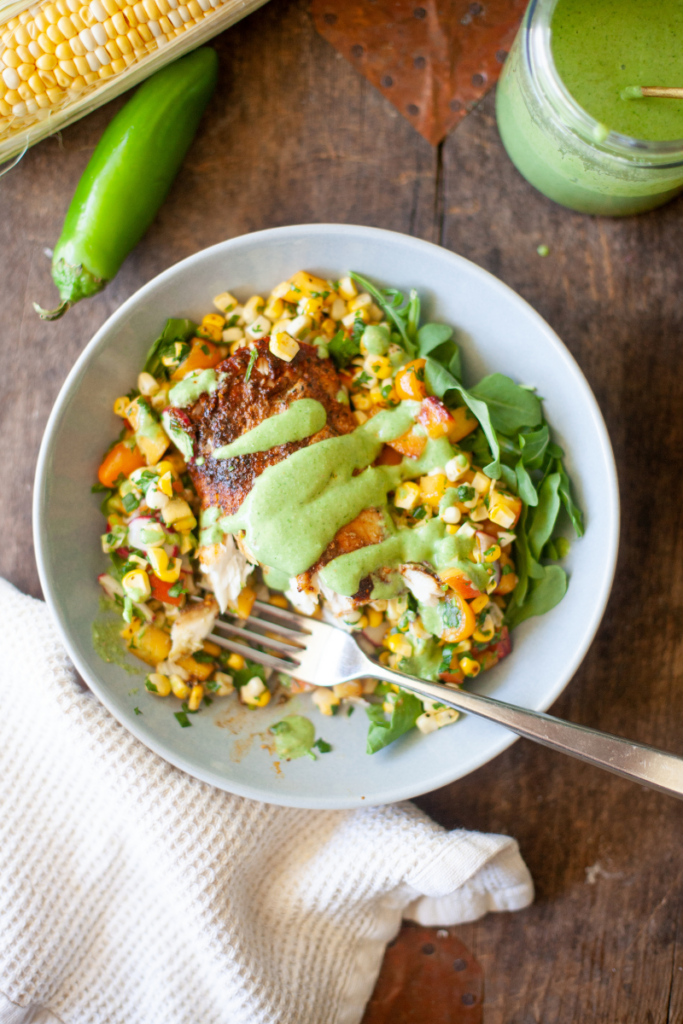 Air fryer blackened mahi mahi with a bite taken out of it in a white serving dish.