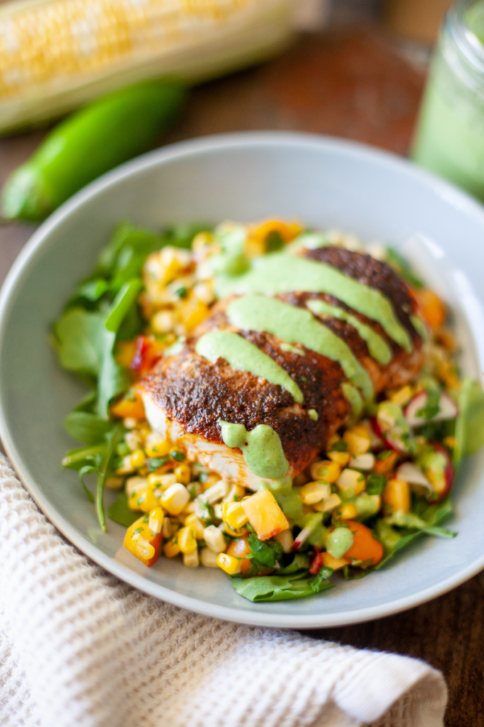 Air fryer Mahi Mahi on a bed of rice and corn in a large white serving dish.