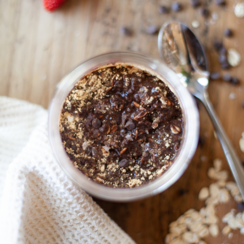 Chocolate protein overnight oats with toppings in glass jar.