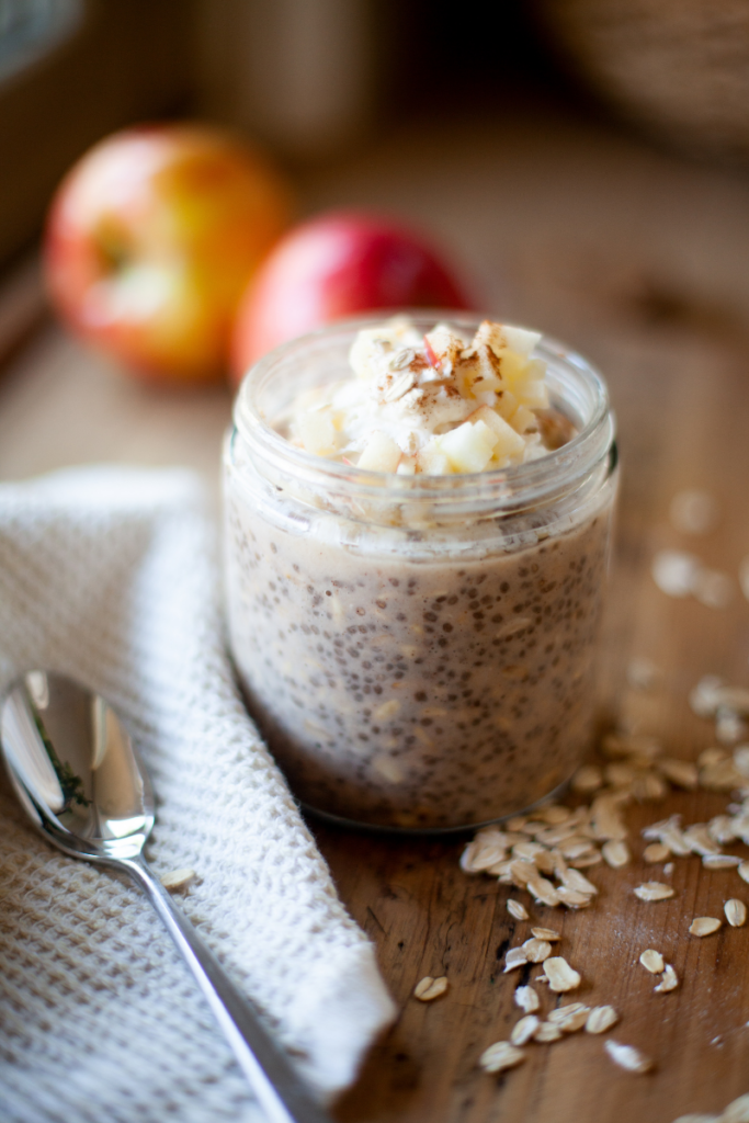 Apple pie overnight oats in a jar with whipped topping.