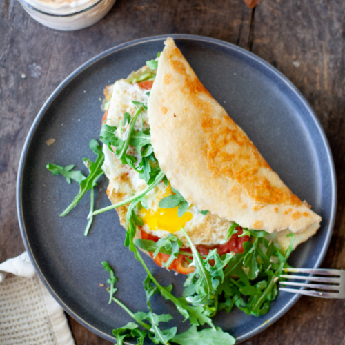 Cheese-fried egg wrap on blue plate.