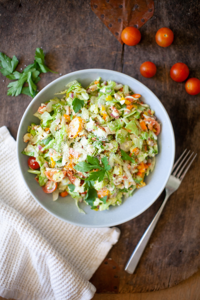 Grinder Salad in a bowl garnished with tomatoes and herbs.