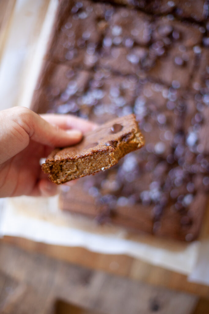 Hand hold a pumpkin pie breakfast bar to show inside of the bars.