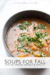 A bowl of hearty soup topped with fresh herbs, placed on a white surface. Text reads: 5 Healthy and Macro-friendly Soups for Fall that are perfect for warming up and staying nourished this season.