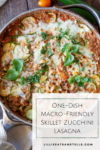A skillet of Skillet Zucchini Lasagna is filled with layers of tender zucchini, topped with melted cheese and fresh basil, sitting on a rustic wooden table. Text overlay reads: One-Dish Macro-Friendly Skillet Zucchini Lasagna.