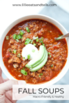 A bowl of chili topped with sour cream, avocado slices, and chopped green onions. The image text reads FALL SOUPS Macro-Friendly & Healthy and highlights 5 Healthy and Macro-friendly Soups for Fall, featuring the website www.lillieeatsandtells.com.