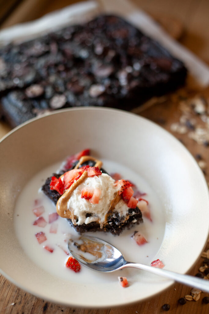 macro-friendly pumpkin chocolate cake with toppings: strawberries, whip cream, and almond drizzle