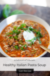 A bowl of Italian Pasta Soup with ground meat, vegetables, noodles, fresh basil, and a dollop of sour cream sits invitingly on the table. Text reads: Healthy Italian Pasta Soup. Get Recipe.