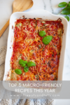 A baked casserole topped with tomato sauce, melted cheese, and fresh basil leaves, in a white dish on a marble counter. Text reads: 5 Most Popular Macro-friendly Recipes from 2023—discover this and more at www.lillieeatsandtells.com.