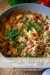 Close-up of a skillet filled with Cajun Chicken Spaghetti Squash Skillet, featuring tender chicken, creamy sauce, chopped tomatoes, fresh herbs, and garnished with parsley. Text overlay reads: Cajun Chicken Spaghetti Squash Skillet.