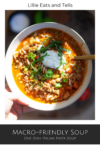 A hand holds a bowl of delicious Italian Pasta Soup topped with fresh herbs and cheese. The soup is filled with ground meat, pasta, and vegetables in a savory tomato broth. Text above reads Lillie Eats and Tells with Macro-Friendly Italian Pasta Soup below.