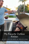 A man grills steaks on an outdoor barbecue in a sunny backyard. The grill is open, showing sizzling meat. Text reads Why I Love My Outdoor Kitchen—My Favorite Outdoor Kitchen, www.LillieEatsAndTells.com.