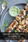 Grilled chicken skewers on a plate with green sauce in a small cup, garnished with herbs. This dish is perfect for anyone interested in macro-focused meal planning. Text overlay reads: MACRO-FOCUSED MEAL PLANNING 101 www.lillieeatsandtells.com.