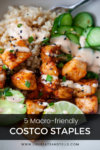 A bowl with brown rice, grilled chicken, cucumber slices, avocado, lime, and creamy sauce, topped with black sesame seeds and chives. Text overlay: 5 Macro-Friendly Costco Favorites.