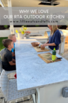 A woman cuts pineapple at an outdoor kitchen counter while two boys sit on stools watching. The text above reads, Why I Love My Outdoor Kitchen www.lillieeatsandtells.com.