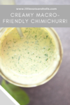 A glass jar filled with creamy, green-flecked Creamy Chimichurri sauce, viewed from above, with a spoon inside. Text overlay reads: CREAMY MACRO-FRIENDLY CHIMICHURRI.