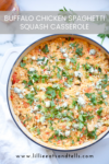A casserole dish filled with Buffalo Chicken Spaghetti Squash Casserole, topped with green onions, herbs, and blue cheese crumbles. Find the full recipe at lillieeatsandtells.com.