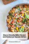 A skillet filled with juicy BBQ chicken, butternut squash, corn, tomatoes, avocado, and fresh herbs sits beside a wooden board. Text overlay reads: BBQ Chicken and Butternut Macro-Friendly Skillet.
