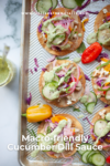 Tostadas topped with sliced cucumbers, pickled onions, veggies, and a vibrant cucumber dill sauce are arranged on a baking sheet. Two small peppers and a jar of cucumber dill sauce sit nearby. Text reads Macro-friendly Cucumber Dill Sauce.