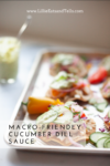 A tray of colorful nachos topped with cucumber slices and a generous drizzle of Cucumber Dill Sauce, with a jar of the creamy green sauce and spoon in the background. Text reads: Macro-Friendly Cucumber Dill Sauce.
